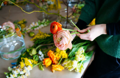 Women hands make bouquet at flower workshop
