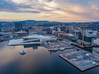 High angle view of river and buildings against sky during sunset