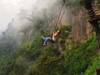 Woman swinging against mountain