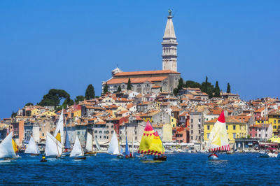 View of buildings at waterfront against blue sky