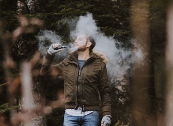 Man smoking electronic cigarette while standing outdoors