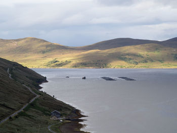 Scenic view of sea and mountains against sky