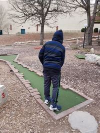 Rear view of man walking on footpath in winter