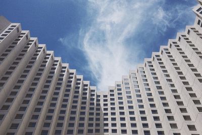 Low angle view of modern building against cloudy sky