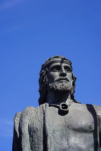 Low angle view of statue against blue sky