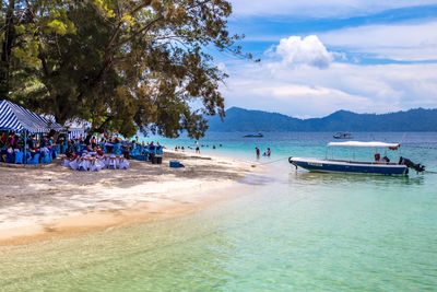 People at beach against sky