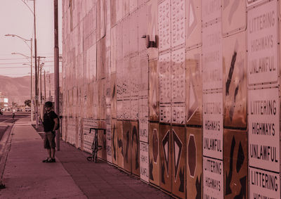 Rear view of woman walking on street amidst buildings