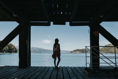 Rear view of woman standing on pier