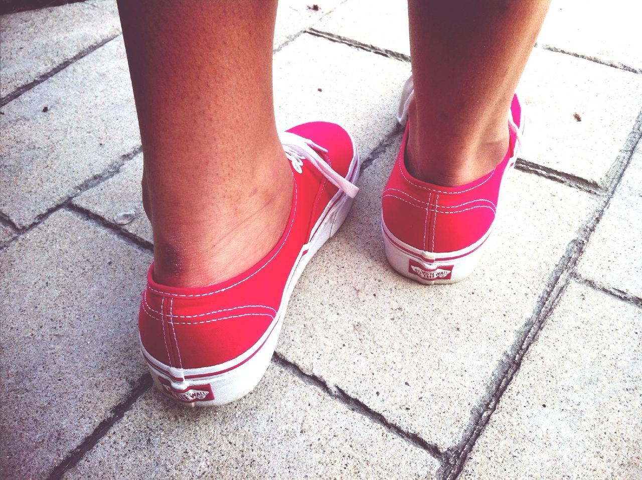 low section, person, red, shoe, lifestyles, street, human foot, high angle view, standing, footwear, tiled floor, leisure activity, part of, sidewalk, sunlight, day