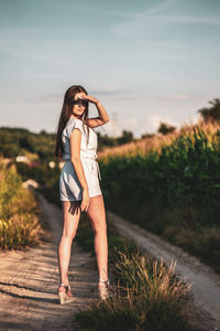 Young beautiful woman with brown hair in the corn field.