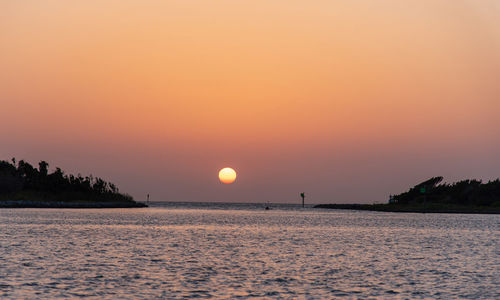 Scenic view of sea against romantic sky at sunset