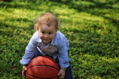 Portrait of cute boy sitting on land