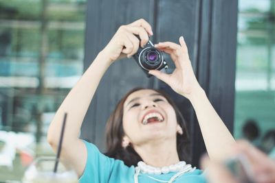 Close-up of laughing woman holding camera