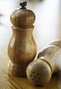 Close-up of salt and pepper wooden cellars on table