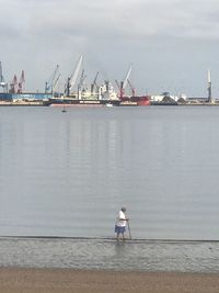 Man standing at harbor against sky