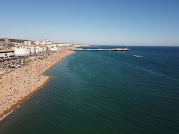 Aerial view of city by sea against clear sky