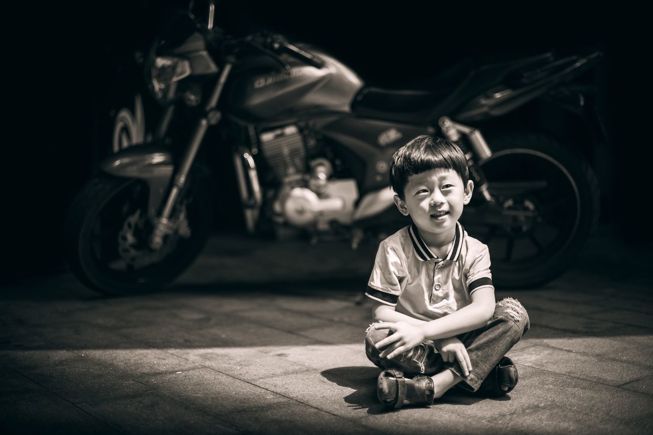 childhood, full length, sitting, one person, real people, crouching, boys, motorcycle, outdoors, portrait, day, people