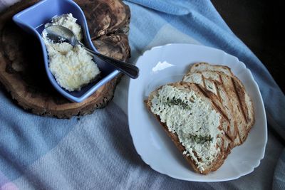 Sandwiches from a loaf and with cheese paste on a wooden stand and in a white plate