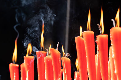 Rows of burning red candles are used in religious prayers