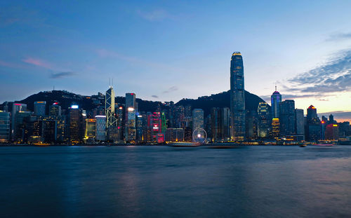 Illuminated buildings in city at waterfront