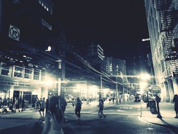 People walking on city street at night