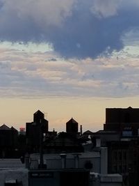 Buildings in city against cloudy sky