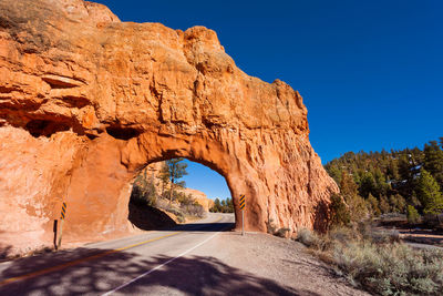 Road amidst rocks against clear blue sky