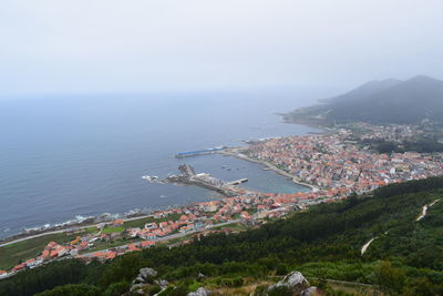 High angle view of townscape by sea against sky