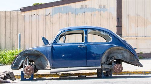 Abandoned car against blue sky