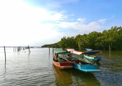 Boats moored in lake against sky