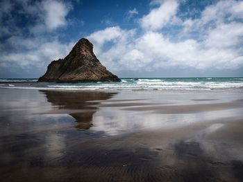 Scenic view of rocks on beach against sky