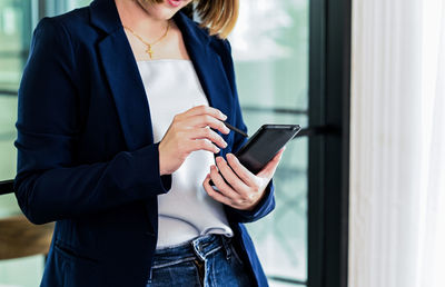 Midsection of woman using mobile phone