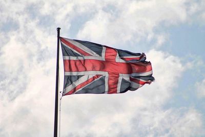 Low angle view of british flag against cloudy sky
