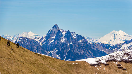 Scenic view of snowcapped mountains against blue sky