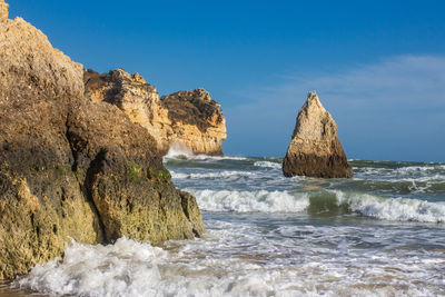 Rocks in sea against sky