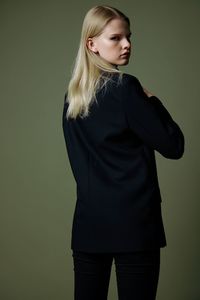 Young woman standing against black background