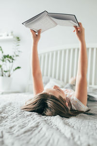 Woman lying down on bed at home