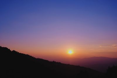 Scenic view of silhouette mountains against sky during sunset