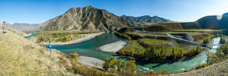 Panoramic view of lake and mountains against blue sky