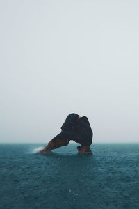 Man exercising in water during rain