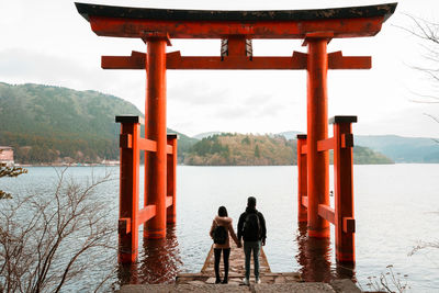 Rear view of couple standing at torii gate