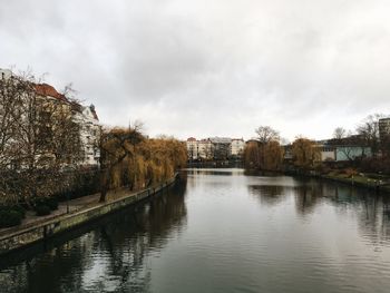 River by buildings against sky