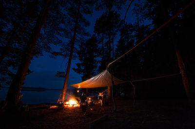 Illuminated tent on field against sky at night