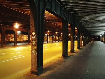 Empty road below bridge at night