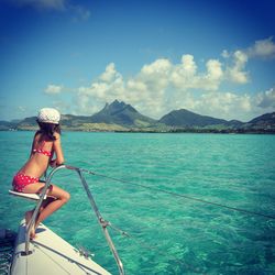 Young woman sailing on sea against sky