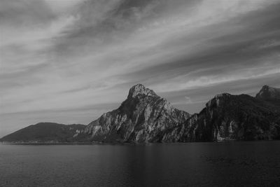 Scenic view of sea by mountains against sky