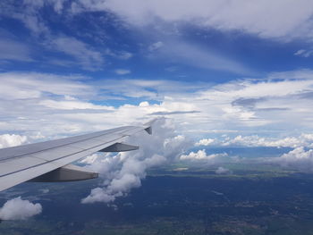 Aircraft wing flying in cloudy sky