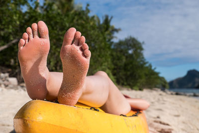 Low section of woman relaxing on beach