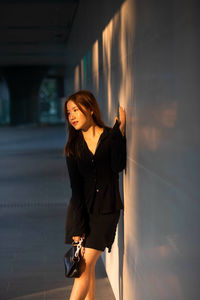 Portrait of young woman standing in city