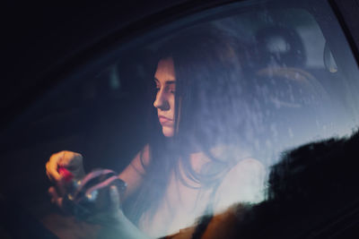 Portrait of young man using smart phone in car